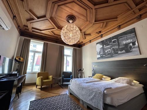 维也纳Hotel Brauhof Wien的一间卧室配有一张床、一张书桌和一个吊灯。
