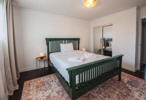 耶洛奈夫Yellowknife Downtown Toboggan Hill Retreat的一间卧室配有绿色的床和镜子