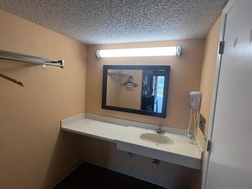 达文波特Rodeway Inn Davenport-Champions Gate的一间带水槽和镜子的浴室