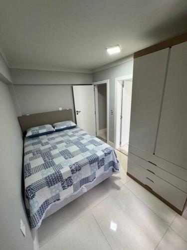 邦比尼亚斯Aparto Canto da Praia /40m d Mar的一间卧室配有一张带 ⁇ 子毯子的床