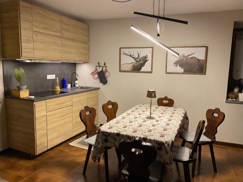 巴多尼奇亚Les Arnauds的一间带桌子和椅子的厨房和一间带桌子的厨房
