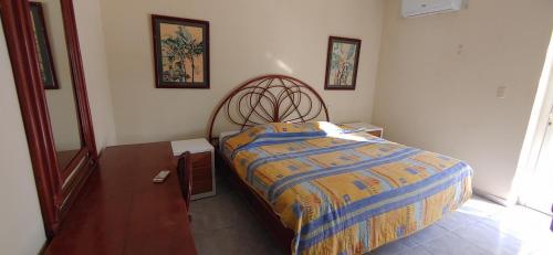 瓜亚卡内斯Residence Caribe的一间卧室配有一张带木制床头板的床