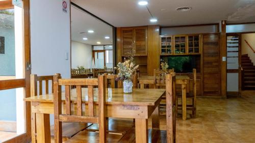 门多萨Hostel Casa Roble的一间带木桌和椅子的用餐室