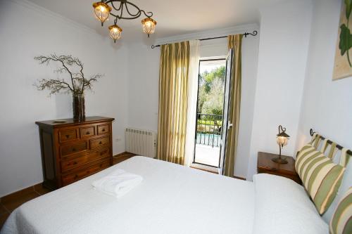 埃尔博斯克Casa Rural Rafael Alberti的卧室配有白色的床和窗户。