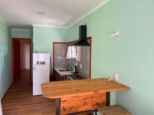 FomentoTechos Amarillos aparthotel的厨房配有木桌和冰箱。