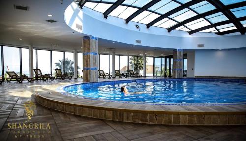 巴统Orbi City Hotel Lux View的在大楼里的大型游泳池游泳的人