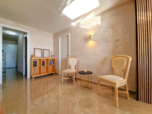 罗列特海岸Lloret Paradise Apartments的客厅配有两把椅子和一张桌子