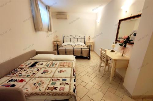 奥斯图尼Bed & Breakfast dei Colli的一间卧室配有两张床、一张桌子和一面镜子