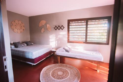 皮帕La Serena Hostel的一间卧室设有两张床、一个窗户和一个地毯。