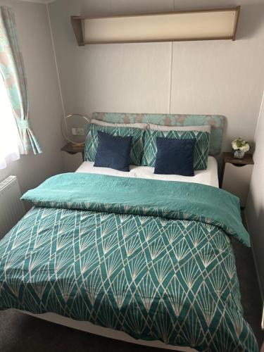 塞顿港Seton Sands Muirfield 6的一间卧室配有一张蓝色和绿色床单。