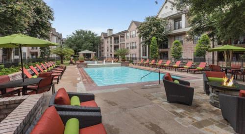 休斯顿Amazing Houston Apartment with Pool+ Fast Internet的一个带桌椅的游泳池以及游泳池