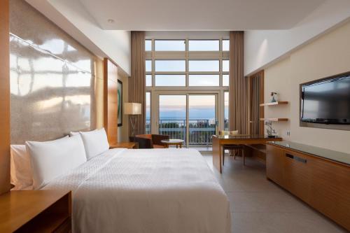 万宁神州半岛福朋喜来登酒店（三亚机场/免税店穿梭巴士/3100㎡礁湖泳池畅游）的一间酒店客房,设有一张大床和一个大窗户