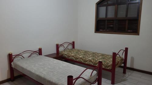 雅里努Chácara com piscina em Jarinu的带窗户的客房内设有两张单人床。