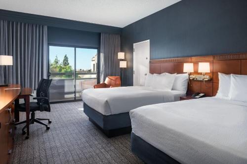 凤凰城Courtyard by Marriott Phoenix Airport的酒店客房配有两张床和一张书桌