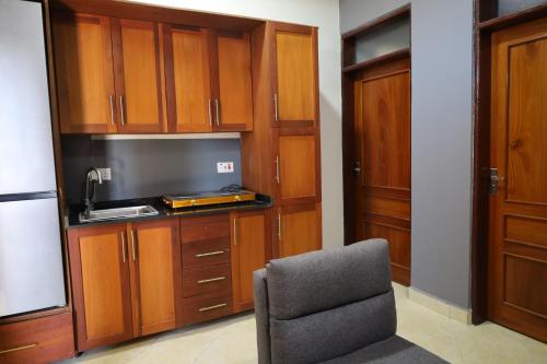 达累斯萨拉姆Morris Multi的一间带椅子的房间和一间带木制橱柜的厨房