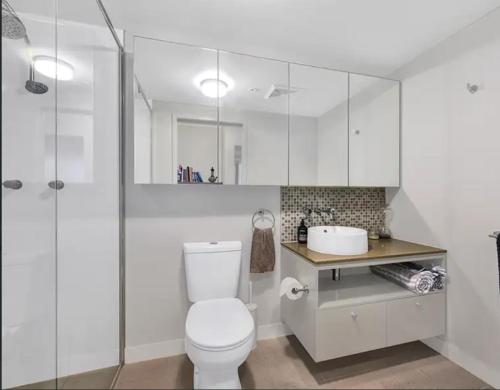 布里斯班Light apartment in amazing central location的白色的浴室设有卫生间和水槽。