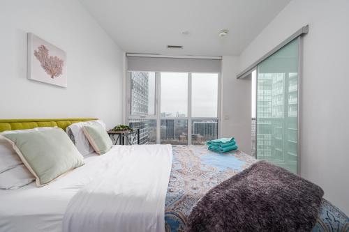 多伦多Luxury properties close to Eaton Center!的一间卧室设有一张大床和一个大窗户