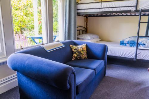 阿卡罗阿Halfmoon Cottage的客厅配有蓝色的沙发和一张双层床。