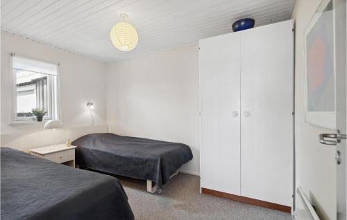 SundsAmazing Home In Sunds With Lake View的一间带两张床和白色大橱柜的卧室
