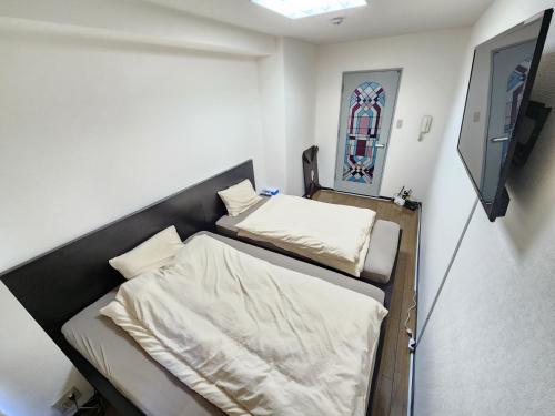 大阪난바역 도보5분 시내중심 MORI Apartment的小房间设有两张床和电视