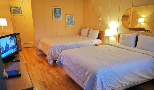 蒙特朗布朗Motel Tremblant的酒店客房设有两张床和一台平面电视。