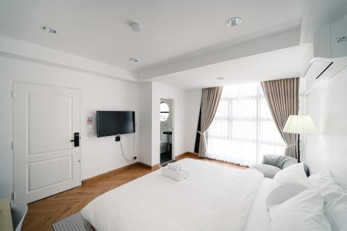 Bang SuMitt Haus (Lat Phrao Soi 5)的白色的客房配有床和电视。