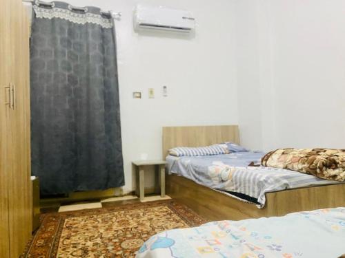Az Zaqāzīqشقة فندقية بالزقازيق的客房设有两张床和窗户。