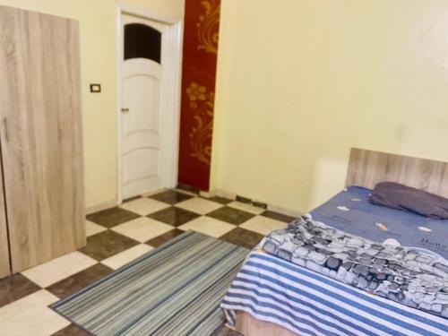 Az Zaqāzīqشقة فندقية بالزقازيق的一间卧室配有一张床,铺有一个 ⁇ 板地板