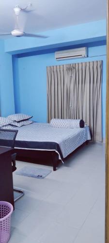 吉大港Home Stay Chittagong的蓝色客房中一间带床的卧室