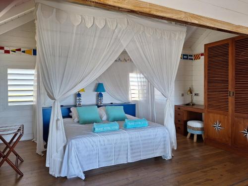 Beach House Lodge的卧室配有白色天蓬床和蓝色枕头