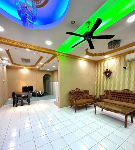 山打根Melody D’Rimba Sandakan的大堂配有沙发和带绿灯的天花板