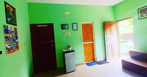 卡兰古特CASA SOMANJO INN的一间设有绿色墙壁、门和冰箱的客房