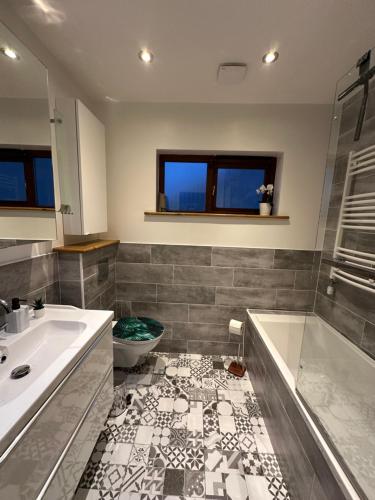 都柏林Blush Jungle的带浴缸、盥洗盆和卫生间的浴室