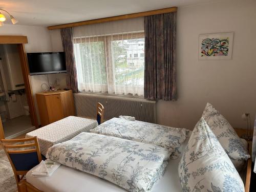 普鲁茨奥地利海斯汽车旅馆的卧室配有带枕头的床铺和窗户。