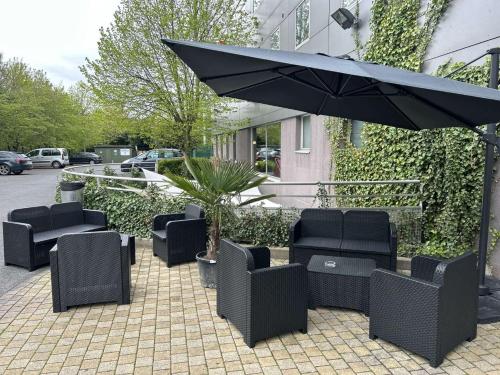 鲁瓦西昂法兰西阿克蒂苏尔斯施坦丁套房酒店的一个带椅子和遮阳伞的庭院