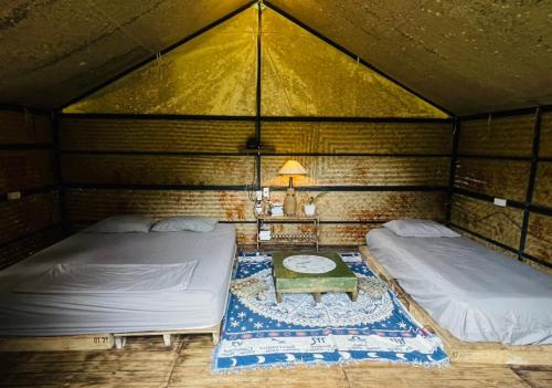 昆岛Con Dao Backpacker - LoCo Camping的一间设有两张床和一张桌子的房间