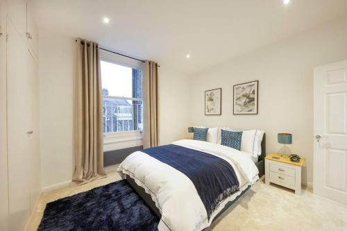 伦敦Stunning Hyde Park Apartment的一间卧室设有一张大床和一个窗户。