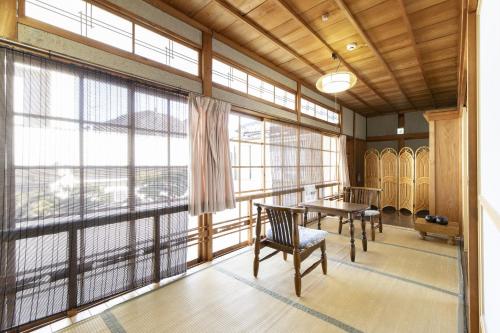 天川村Ichimaru Ryokan - Vacation STAY 35990v的客房设有桌椅和大窗户。