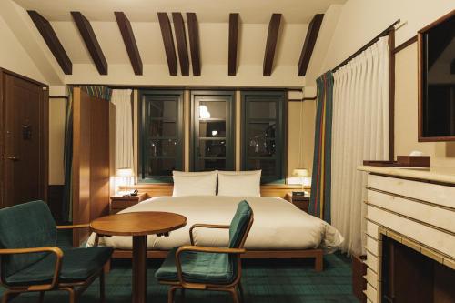 京都Marufukuro的酒店客房带一张床、一张桌子和椅子