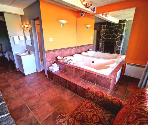 蒙特朗布朗Motel Tremblant的带浴缸和大镜子的大浴室