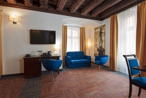 波兹南Palazzo Rosso Old Town的酒店客房配有蓝色椅子和书桌,