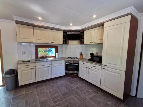 皮滕Chalet Rust-ique的厨房配有白色橱柜和炉灶烤箱。
