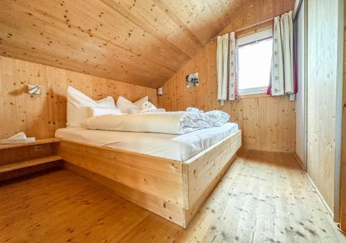 巴特圣莱昂哈德艾1A Chalet Rast - Grillen mit Traumblick, Indoor Sauna的木制客房内的一间卧室,配有一张床