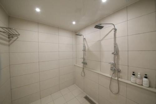 大田Hotel141的白色瓷砖浴室设有淋浴。