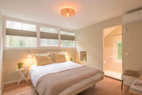 奥门Huishotel Bed bij Bort的一间卧室设有一张床和两个窗户。
