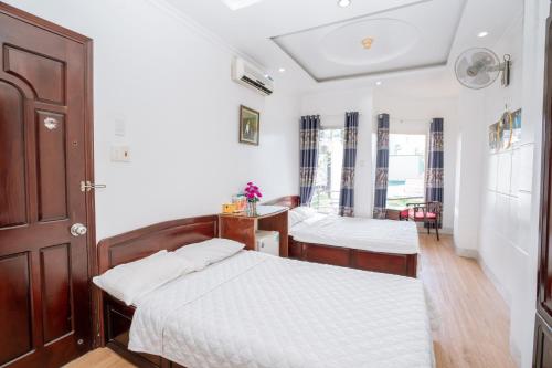 邦美蜀Triệu Vũ Hotel & Apartment的一间卧室配有两张床和一张桌子