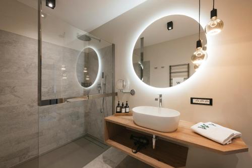 拉纳Boutique Hotel Wiesenhof - Adults Only的一间带水槽和镜子的浴室
