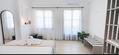 古卡斯特隆Sunrise的白色的房间,床上有毛巾