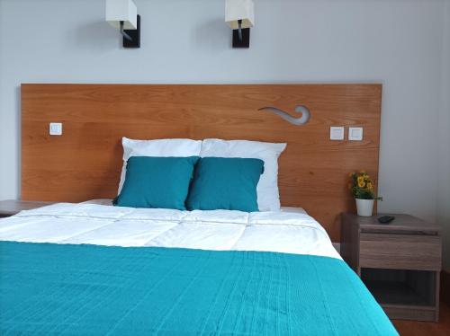 MourjouAuberge de Mourjou的一张铺有蓝色和白色床单的床和木制床头板