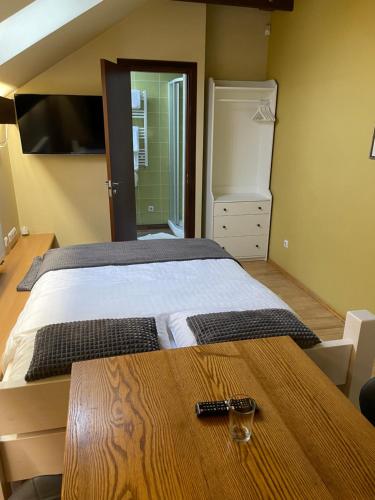 马里扬泊列Akmenine Kerpe的一间卧室配有一张床和一张木桌